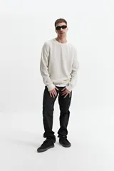 Buzo de punto oversize color negro, con escote redondo y puños.