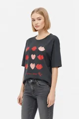 Remera marrón de manga corta con cuello redondo y diseño holgado. En el frente presenta una estampa en tono verde claro con forma de corazón, estrellas y la frase 'You are my lucky'.