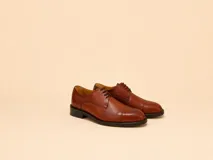 Zapato de vestir estilo Oxford con puntera reforzada, confeccionado en cuero de tono marrón con acabado pulido y cordones al tono.
