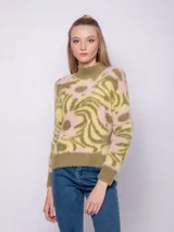 Polera de tejido de punto con diseño de jacquard en tonos verde y rosa. Es de textura peludita, manga larga y cuello alto.