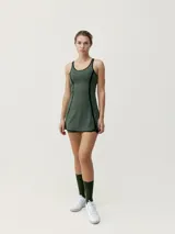 Vestido deportivo color verde militar con tirantes y ribetes negros, ideal para pádel o tenis. Incluye sujetador incorporado de sujeción media-alta y abertura lateral en la falda.