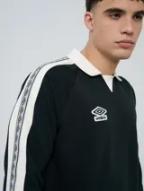 Buzo deportivo Umbro modelo Mixtape, color negro con cuello polo blanco y franjas blancas en las mangas con logo de la marca. Cuenta con puños y cintura elastizados.