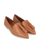 Zapato de cuero color caramelo, estilo mocasín con puntera fina y detalle de borla en el empeine. Cuenta con un tacón bajo con detalle metálico dorado.