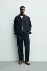 Pantalón straight fit color negro, confeccionado en popelín de algodón, con cintura elástica y bolsillos frontales.