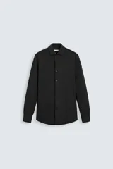 Camisa de manga larga color celeste claro, corte slim fit, con cuello italiano abierto y cierre frontal de botonadura.