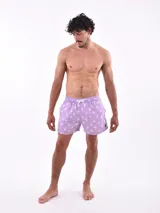Short de baño blanco con estampado de hojas en tonos azules y rosados, cintura elástica con cordón ajustable.