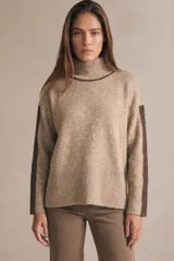 Polera oversize color beige melange, de punto con mangas largas y detalles de franjas marrones en las mangas y cuello.