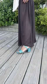 Sandalia de tacón cuadrado medio, con diseño de tiras horizontales y punta cuadrada. Presenta un acabado metalizado en color turquesa y cierre con pulsera al tobillo.