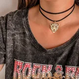 Gargantilla doble de cuero negro con dije de tigre dorado.