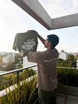 Remerón marrón con estampado frontal con la palabra "RELAJO" y un logo abstracto.