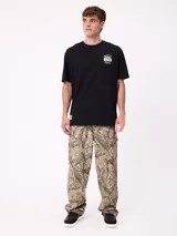 Remera negra de corte holgado con estampa gráfica en la espalda que representa un paisaje natural con árboles, una van y el texto 'Rusty' y 'Designed for disconnection'.