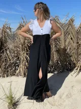 Vestido largo de corte evasé, con cuerpo superior blanco con volados en los hombros y falda negra con botones frontales.