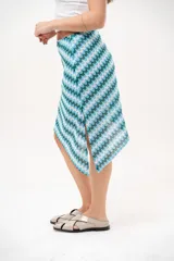 Falda asimétrica de crochet con diseño de ondas en tonos azules, celestes y blancos.