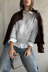 Sweater de punto con diseño de rombos en tonos gris y beige, cuello redondo, mangas largas y puños acanalados.