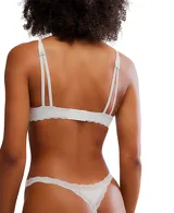 Bralette de algodón negro con escote profundo y terminaciones de encaje en color crema en los bordes.