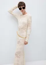 Vestido largo de punto calado con diseño de paneles geométricos, cuello redondo y manga larga. Presenta un corte entallado y un acabado en color crudo.
