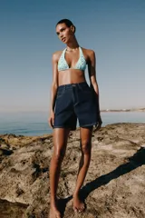 Shorts de denim azul oscuro con tiro alto, calce mom fit y diseño de cinco bolsillos con costuras en contraste.