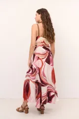 Vestido largo sin mangas de corte evasé con estampado abstracto en tonos bordó, beige y rosado, escote en V y tirantes finos.