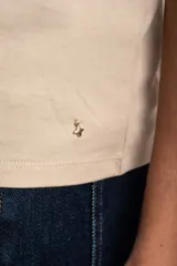 Remera de algodón peinado color marfil, de manga corta y corte al cuerpo, con escote en V ribeteado con hilo dorado.