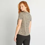 Camiseta de manga corta con estampado animal print en tonos beige y marrón.