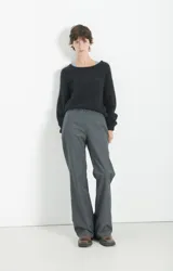 Polerón de punto negro con textura esponjosa, corte holgado y mangas largas. Presenta un diseño de cuello redondo y acabado suave al tacto.