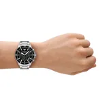 Reloj cronógrafo Emporio Armani con caja de acero inoxidable de 43 mm, esfera negra con subesferas y malla de acero plateado. Cuenta con movimiento solar, indicador de fecha y resistencia al agua de 10 ATM.