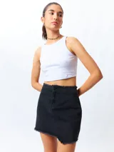 Minifalda de jean negra con corte asimétrico en el frente y deflecado tanto en la cintura como en el ruedo.