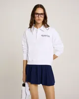 Buzo blanco de algodón con cuello polo y mangas largas. Estampado frontal con el texto "New York Racquet Club Sporty & Rich".