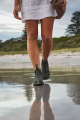 Botas tipo chelsea Blundstone modelo 587, confeccionadas en gamuza repelente al agua de color gris oscuro. Presentan paneles elásticos laterales negros, tiradores en la parte superior y suela de TPU antideslizante con entresuela acolchada para mayor absorción de impactos.