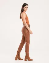 Pantalón negro estilo jeanero confeccionado en gabardina elastizada con terminación metalizada, pierna recta con largo por arriba del tobillo, cierre delantero y botón.