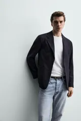 Blazer de corte relaxed fit con cuello de solapas de muesca y cierre frontal de un botón. Cuenta con bolsillos de plastrón en la cadera y mangas largas.