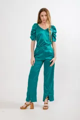 Pantalón negro de seda con tiro alto, corte recto, pinzas en la pretina y tajos en el ruedo.