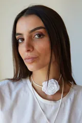 Gargantilla blanca con tiento sintético y dije de flor blanca.