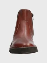 Bota tipo Chelsea de cuero color marrón, con paneles elásticos laterales en color negro y suela de goma dentada.