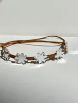 Gargantilla de cuero marrón con flores de acrílico rosado y tiras de cuero para atar.