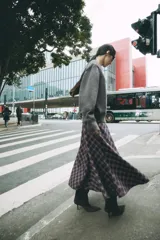 Falda midi de tiro alto ZARA Woman Collection, con diseño evasé y estampado de cuadros en tonos oscuros con líneas rojas y blancas. Cuenta con cierre lateral con cremallera oculta.