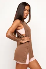 Musculosa de corte holgado y diseño minimalista, confeccionada en una mezcla de viscosa, lino y elastano. Presenta sisas amplias y aberturas laterales en el ruedo, ofreciendo una caída natural y ligera.