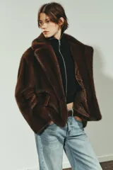 Abrigo corto de Zara con diseño de efecto pelo, cuello de solapa con muescas, manga larga y bolsillos frontales con solapa. Cuenta con forro interior a tono y cierre frontal con botón.