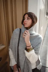 Poncho tejido de lana con cuello alto y diseño de calce relajado, ideal para capas de abrigo.