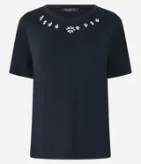 Remera negra de viscosa con cuello redondo y mangas cortas. Presenta apliques de strass en el escote.