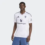 Camiseta de fútbol Adidas del Manchester United, modelo segunda equipación 25/26, para hombre. Diseño blanco con cuello redondo y detalles en violeta. Presenta un patrón sutil en la tela, logo de Adidas, escudo del club con acabado metalizado y sponsor Snapdragon en el frente.