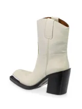 Bota corta de cuero color blanco con puntera metálica plateada, caña media, taco bloque negro y suela negra.