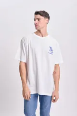 Remera blanca de corte amplio con estampa en la espalda que incluye texto y dibujo de una reposera.