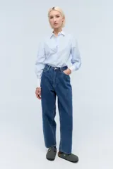 Jean de calce mom, 100% algodón, con lavado azul medio y bordado exclusivo en el interior de la cintura.