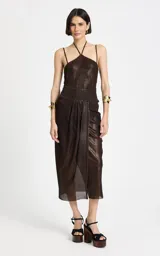 Top de punto brillante color marrón oscuro, con diseño ceñido al cuerpo, escote halter con finos tirantes cruzados, ribete acanalado y espalda descubierta.
