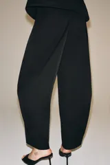 Pantalón de tiro medio con corte recto, confeccionado en tejido con mezcla de algodón. Presenta cintura con trabillas, bolsillos laterales ocultos en costura, raya planchada en el delantero y cierre frontal con cremallera, botón y ganchos metálicos.
