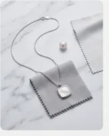 Collar de cadena fina de plata con dije cuadrado de nácar engastado en marco de plata.