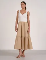 Vestido largo combinado de la marca Elan, con torso en tejido de punto acanalado blanco de escote en V y breteles anchos, y falda midi fluida en color beige con volante fruncido en el ruedo.