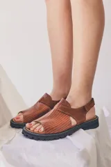 Sandalias marrones con tiras de cuero texturizado y suela track negra.