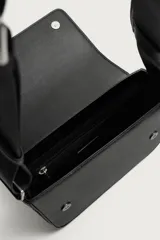 Bandolera de cuero sintético con textura grabada, color negro, solapa frontal con cierre magnético y herrajes plateados. Incluye correa ajustable de cinta y un pequeño monedero desmontable incorporado.